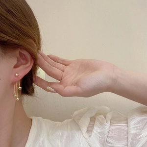 Elegant gold-plated metal ball tassel earrings shown being worn for a stylish look