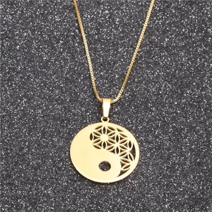 Macro detail of gold-tone stainless steel Yin Yang pendant with Flower of Life pattern