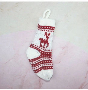 Détail de la chaussette de Noël en tricot rouge et blanc avec motifs rennes et flocons