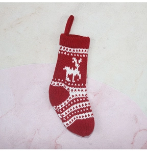 Gros plan d'une chaussette de Noël en tricot rouge et blanc avec motifs de rennes
