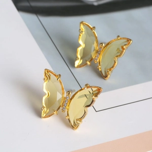 Macro shot of yellow butterfly earrings with gold plating and sparkling crystal accents