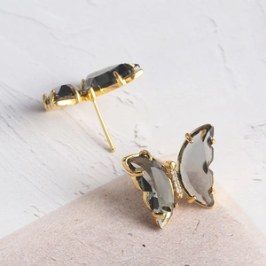 Elegant butterfly stud earrings with smoke grey glass wings and gold-plated metal finish