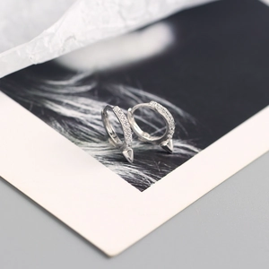 Gros plan sur boucles d'oreilles créoles S925 avec zircons et rivets de style punk