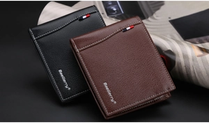 Close-up of black and brown bifold wallets with lychee texture and tricolor ribbon details