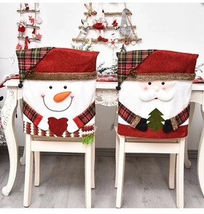 Detail of Santa and Snowman chair covers on white wooden chairs in a festive setting