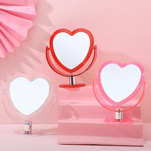 Three desktop heart-shaped vanity mirrors in red, transparent, and pink colors