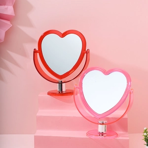 Pink and red heart-shaped desktop makeup mirrors displayed on a tiered vanity stand