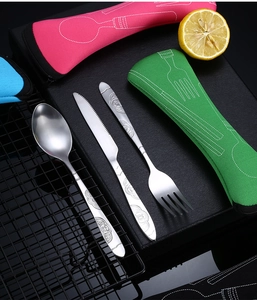 Detail of stainless steel cutlery set with floral engraving and colorful storage pouches