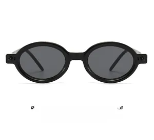 Detailed view of black oval sunglasses with thick frames and round metallic rivets
