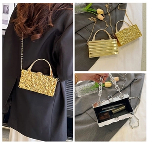 Detailed view of gold and silver box bags with stripe texture and acrylic chain