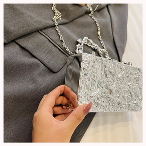 Close-up of silver box bag featuring irregular lava texture and stylish chain strap