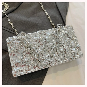 Close-up of silver rectangle box bag with irregular metal texture and chain strap