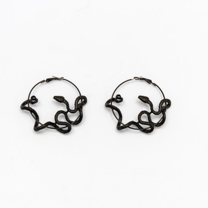 Detailed macro shot of textured snake-shaped hoop earrings in a dark black metallic finish