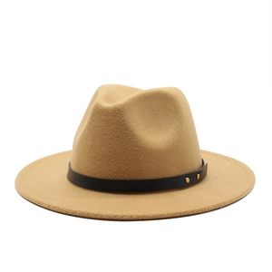 Detail of khaki wool fedora with black leather belt and gold rivet accents on white base