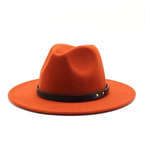 Detail of orange wool fedora featuring a black leather band and gold metal studs