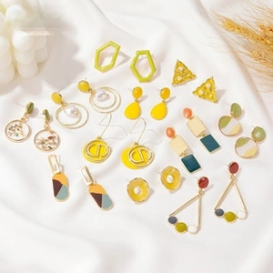 Detail of vintage sun and moon earrings with asymmetric face design on silk fabric