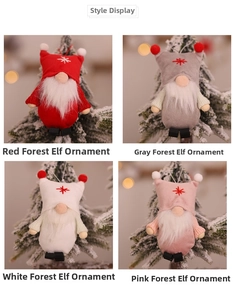 Plush Christmas gnome ornaments in red grey white and pink hanging on a pine tree branch