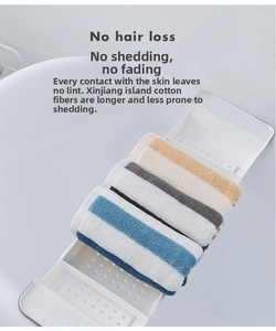 Close-up of four thick cotton face towels in stripes and solid colors on a white shelf