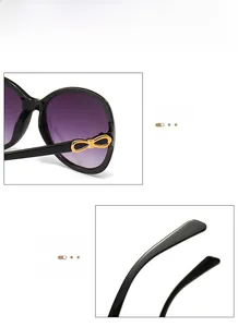 Detail showing gradient purple lenses and golden bow-knot decor on black frame sunglasses