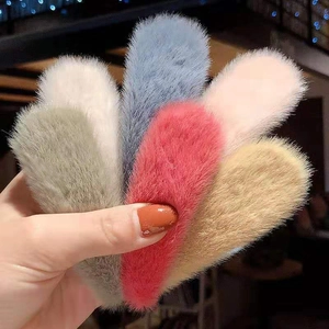 Macro shot of colorful plush fur BB clips in pink, grey, and beige for women