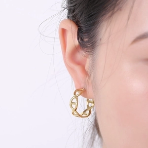 Macro shot of 18K gold plated titanium earring featuring a geometric pig nose design