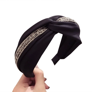Serre-tête élégant en tissu noir avec nœud torsadé et bordure en strass brillant