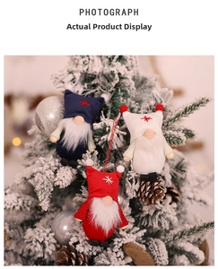 Three plush Christmas gnome ornaments hanging on a snowy tree with stars and pinecones