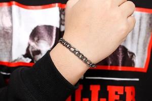 Detailed close-up of retro stainless steel NK curb chain bracelet on a male wrist