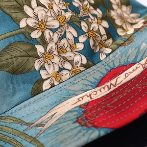 Close-up of ocean botanical patterns and artistic lettering on a fabric sun hat
