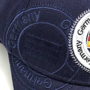 Dettaglio del ricamo della bandiera tedesca su un cappellino in cotone blu scuro