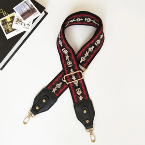Close-up of adjustable ethnic pattern wide strap with gold metal swivel hooks