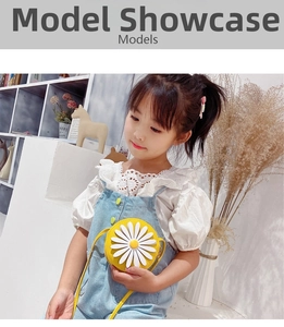Close-up of yellow round crossbody bag with large daisy flower decoration on kid model