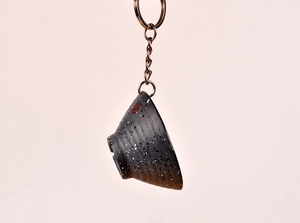 Close-up of a creative bowl-shaped keychain with a red blessing character and chain