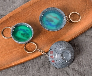 Detail of ceramic mini tea cup keychain with emerald green glaze and metal ring chain