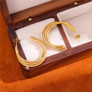 Three-layered golden stainless steel C-shaped hoop earrings inside a wooden jewelry box