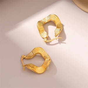 Irregular wavy titanium steel hoop earrings in golden finish with a metallic texture