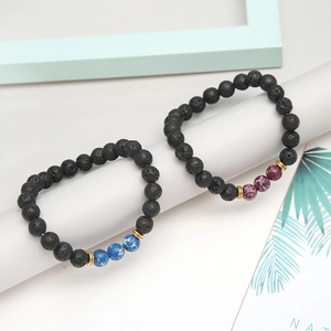 Detailed view of elastic lava stone bracelets with blue and purple beads on white decor