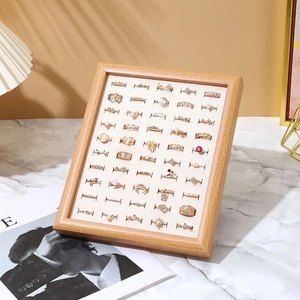 Detail of walnut wood jewelry display tray with beige velvet slots for 50 rings
