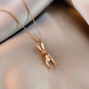 Detail of rose gold rabbit pendant necklace with Luck engraving on fine bead chain