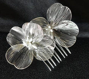 Dettaglio di un pettine per capelli argento con fiori in metallo e perline