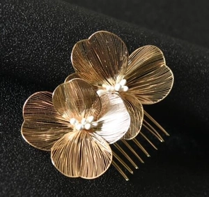 Dettaglio del pettine per capelli dorato con fiori in filo e perline bianche