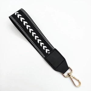 Woven black wristlet strap with white herringbone pattern and gold metal clasp