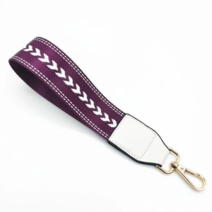 Macro shot of purple woven wrist strap with white V-stitching and golden lobster clasp