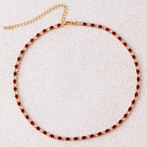 Detail of gold tennis necklace featuring alternating red and white cubic zirconia stones
