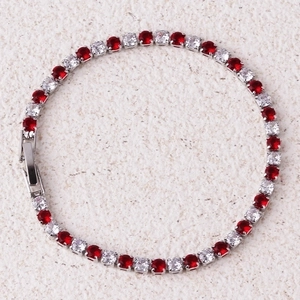 Macro view of silver tennis bracelet with alternating red and clear cubic zirconia stones