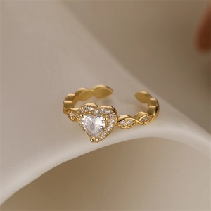 Macro shot of gold heart ring with micro-pave cubic zirconia on a cream background