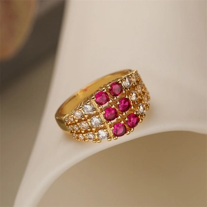 Close-up of gold geometric wide ring with red and white pave-set cubic zirconia stones