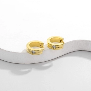 Macro shot of gold hoop earrings with sparkling cubic zirconia on a minimalist base