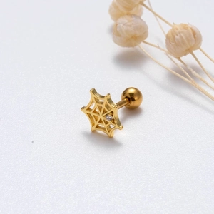 Macro view of a gold spider web earring with central crystal and screw ball back
