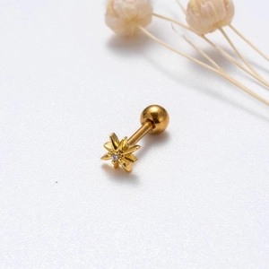 Detailed view of gold star-shaped ear stud with center gemstone and ball back screw